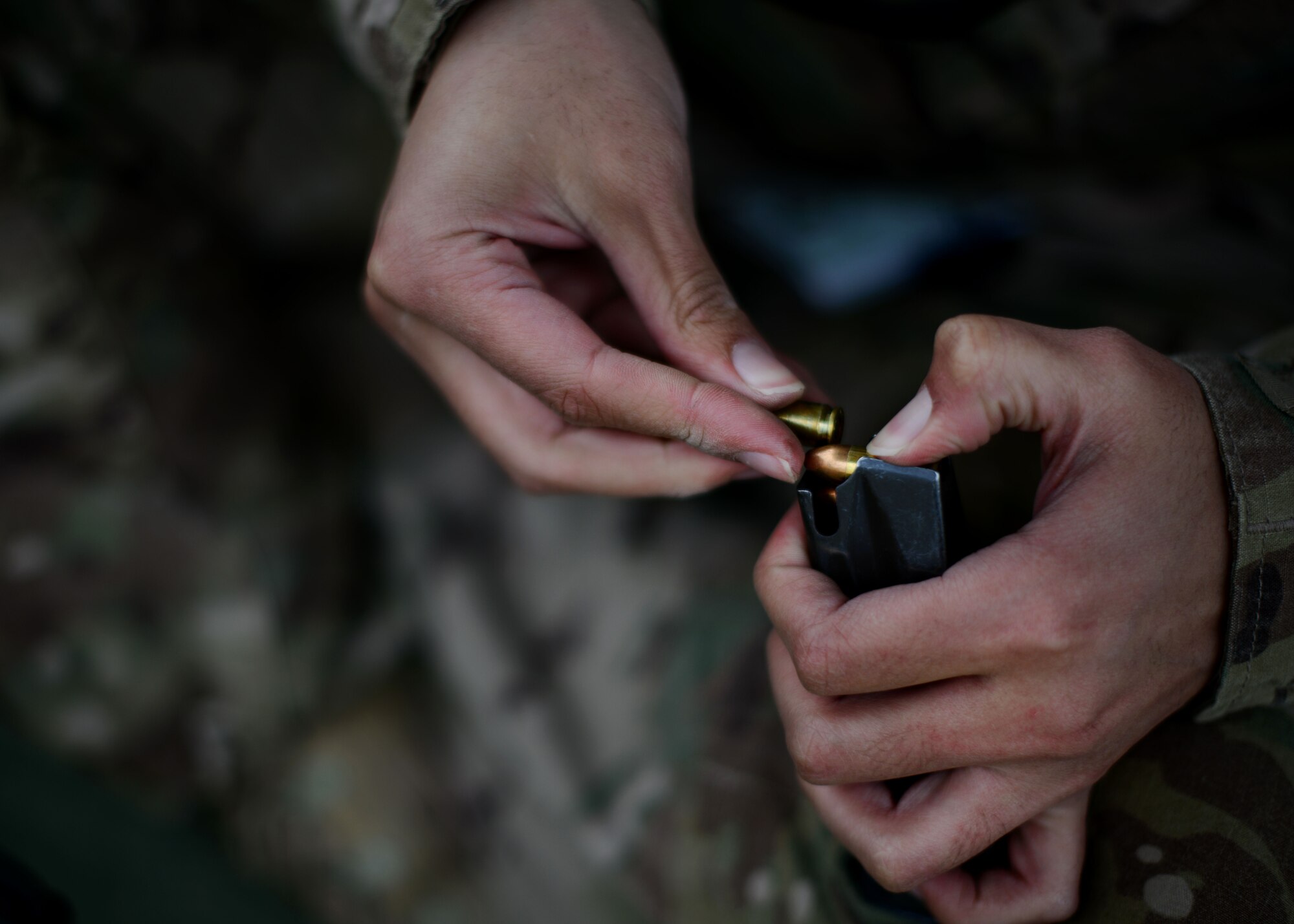A U.S. Airman loads ammunition into a magazine before zeroing her weapon May 17, 2014 at Bagram Airfield, Afghanistan.  Airmen and Soldiers share the local firing range, currently several Air Force combat arms training instructors assist the Army with range operations. (U.S. Air Force photo by Staff Sgt. Evelyn Chavez/Released)