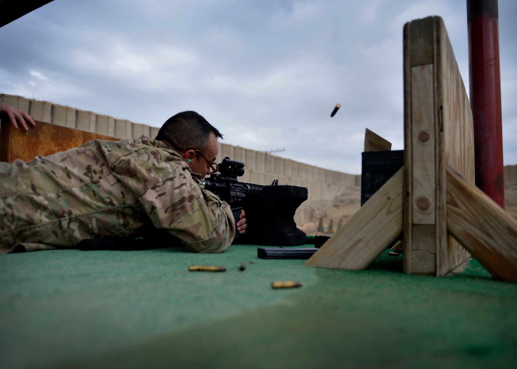 A U.S. Soldier shoots a rifle for weapons qualification May 17, 2014 at Bagram Airfield, Afghanistan.  Airmen and Soldiers share the local firing range; currently several Air Force combat arms training instructors assist the Army with range operations. (U.S. Air Force photo by Staff Sgt. Evelyn Chavez/Released)