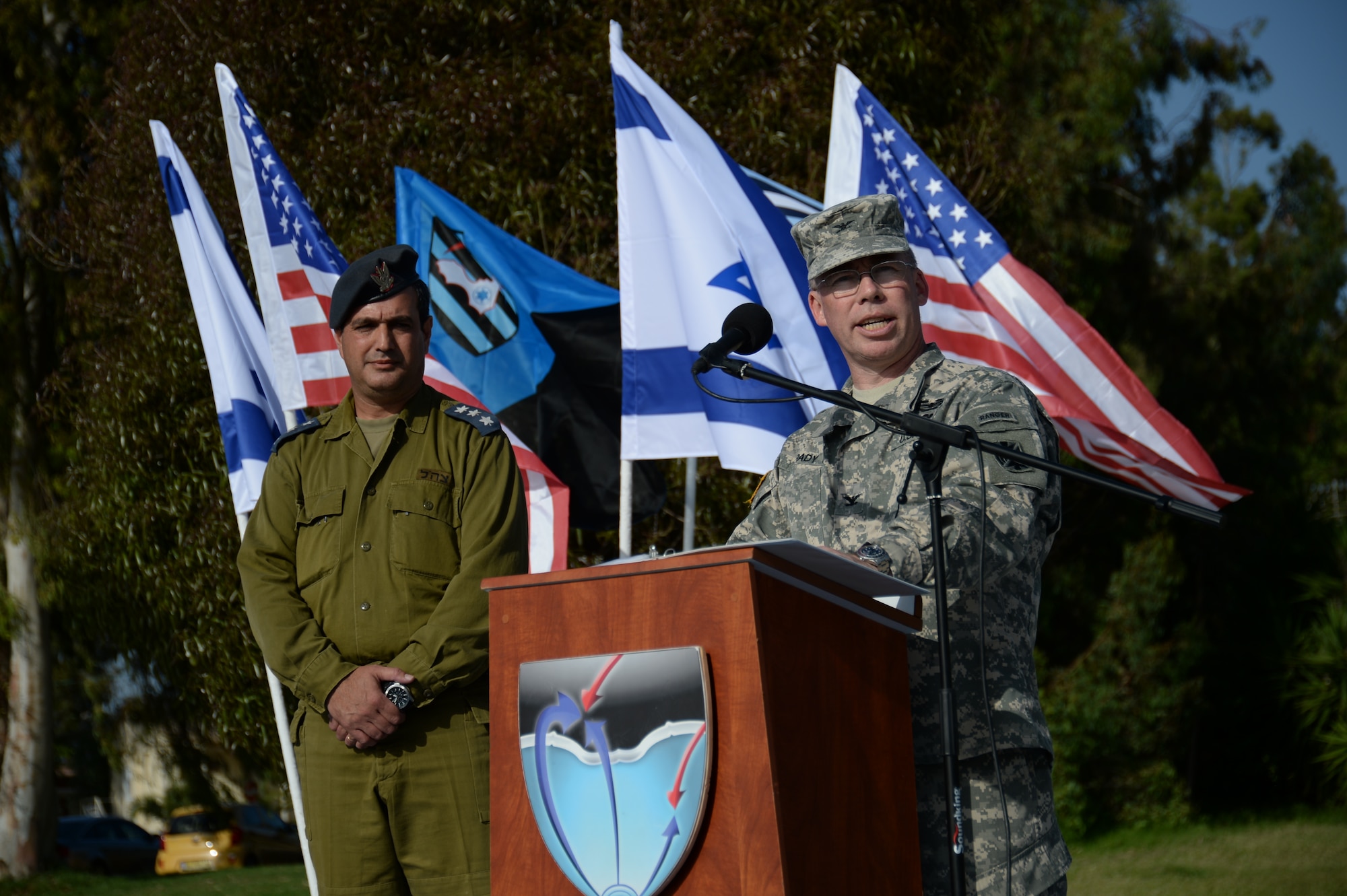 U.S. Army Col. Greg Brady, commander of the 10th Army Air Missile Defense Command, right, speaks as Israeli Defense Forces Col. Zvika Haimovich, commander of the 167th Active Defense Wing, left, listens during the closing parade ceremony of the Juniper Cobra 14 bilateral exercise at Hatzor Air Base, Israel, May 22, 2014. JC14 is driven by the regional dynamics of the Middle East but is not related to any specific current incident or development.   (U.S. Air Force photo by Staff Sgt. Joe W. McFadden/Released)