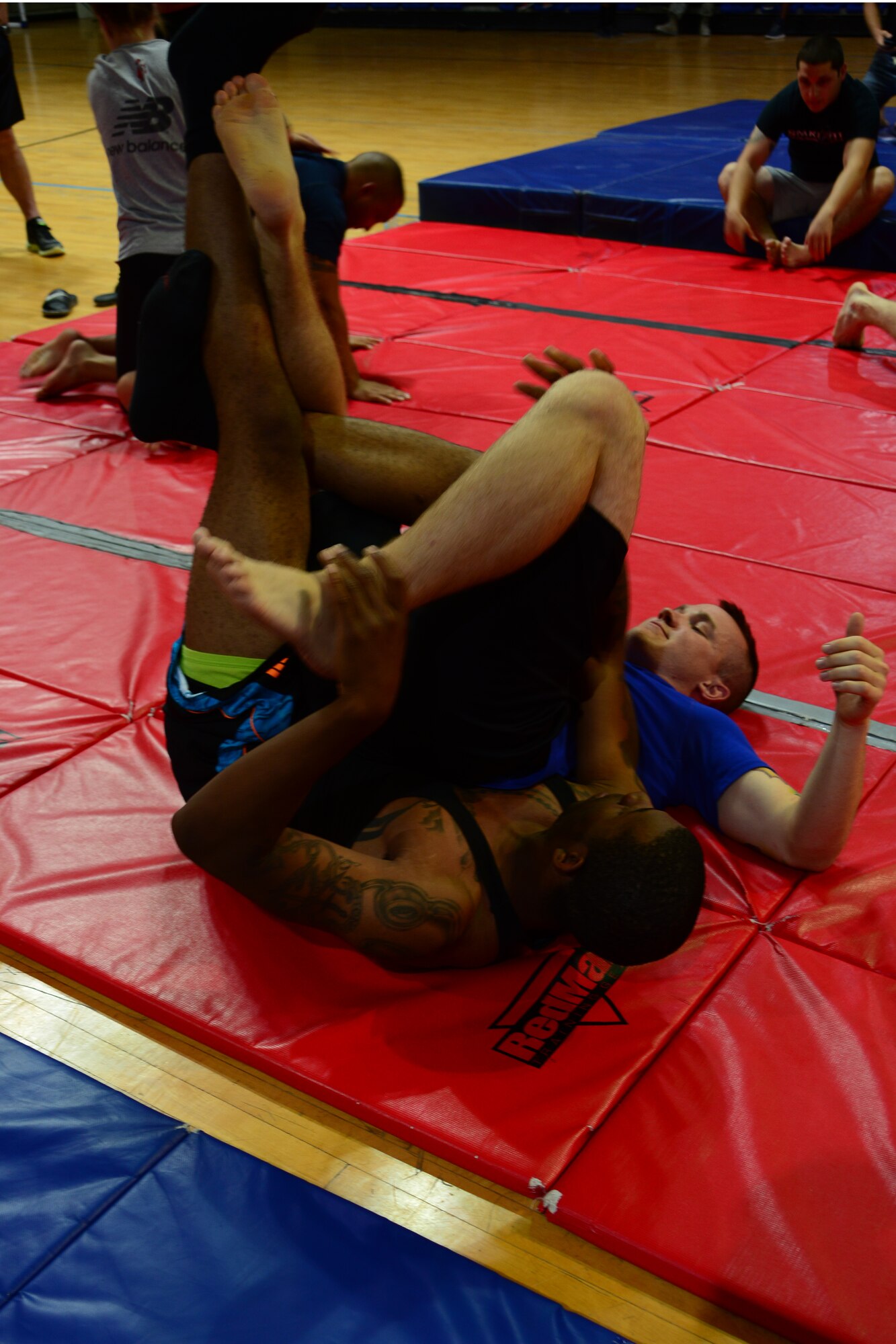 U.S. Air Force Senior Airman Anthony Pierce, left, and Airman 1st Class Cody Meyer practice Mixed Martial Arts moves at Al Udeid Air Base, Qatar, May 23, 2014.  Pierce is deployed from Shaw Air Force Base and hails from Columbus, Georgia.  Meyer is deployed from Ramstein Air Base and hails from Sidney, Nebraska.  MMA fighters came to the base and held an instructional clinic for all interested service members.  (U.S. Air Force Photo by Master Sgt. Marcelo Joniaux)