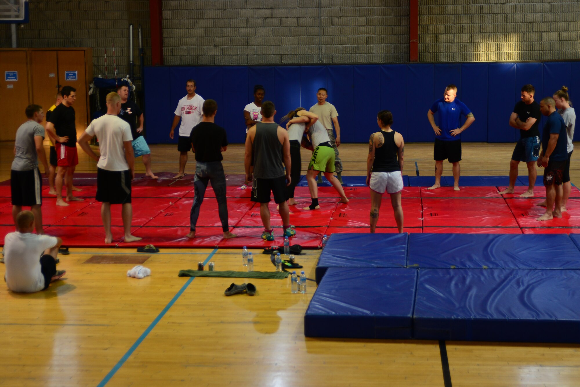U.S. Service members watch Mixed Martial Arts fighters demonstrate fighting techniques at Al Udeid Air Base, Qatar, May 23, 2014.  The demonstration was part of MMA fighters visiting the area of responsibility and teaching Service members their craft.  (U.S. Air Force Photo by Master Sgt. Marcelo Joniaux)