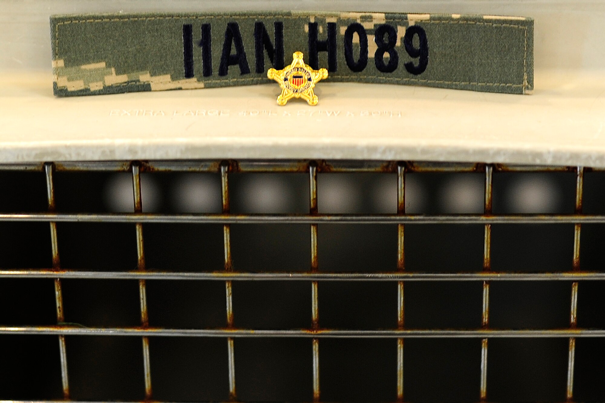 Deceased military working dog Iian’s badge and name tape are displayed on his kennel during the memorial at Kunsan Air Base, Republic of Korea, May 21, 2014. (U.S. Air Force photo by Senior Airman Taylor Curry/Released)