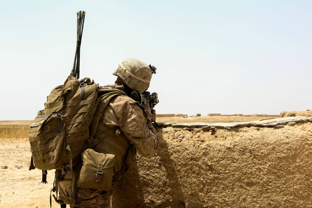 U.S. Marine Corps Lance Cpl. David Brooks takes cover behind a wall during a reconnaissance patrol near Patrol Base Boldak in Helmand province, Afghanistan, May 15, 2014. Brooks, a rifleman, is assigned to Charlie Company, 1st Battalion, 2nd Marine Regiment.