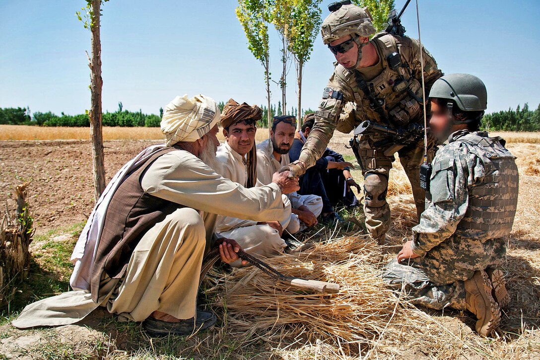 U.S. Capt. Joseph Driskell greets farmers during a partnered patrol near Muqor in Afghanistan's Ghazni province, June 25, 2012. Driskell, a company commander, is assigned to the 82nd Airborne Division's 1st Battalion, 504th Parachute Infantry Regiment, 1st Brigade Combat Team.  
