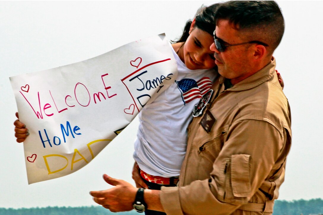 Marine Corps Maj. James Poppy embraces his daughter, Lauren, during an Independence Day homecoming celebration on Marine Corps Air Station Cherry Point, N.C., July 4, 2012. Poppy is the detachment officer-in-charge of Marine Aerial Refueler Transport Squadron 252.  
