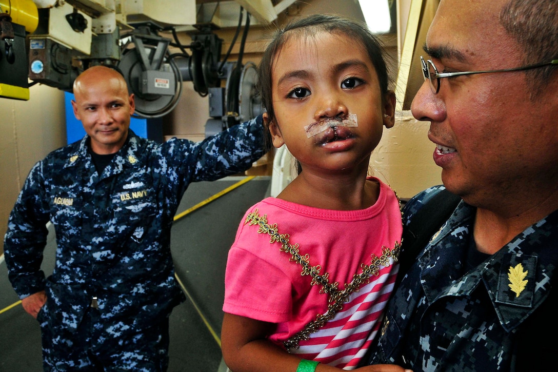 Navy Lt. Cmdr. Dennis Flores holds a patient who received cleft lip repair surgery aboard the USNS Mercy during Pacific Partnership 2012 in Samar, Philippines, June 29, 2012. Pacific Partnership is an annual U.S. Pacific Fleet humanitarian and civic assistance mission designed to work by, with and through host and partner nations, non-government organizations and international agencies to build partnership among nations.  
