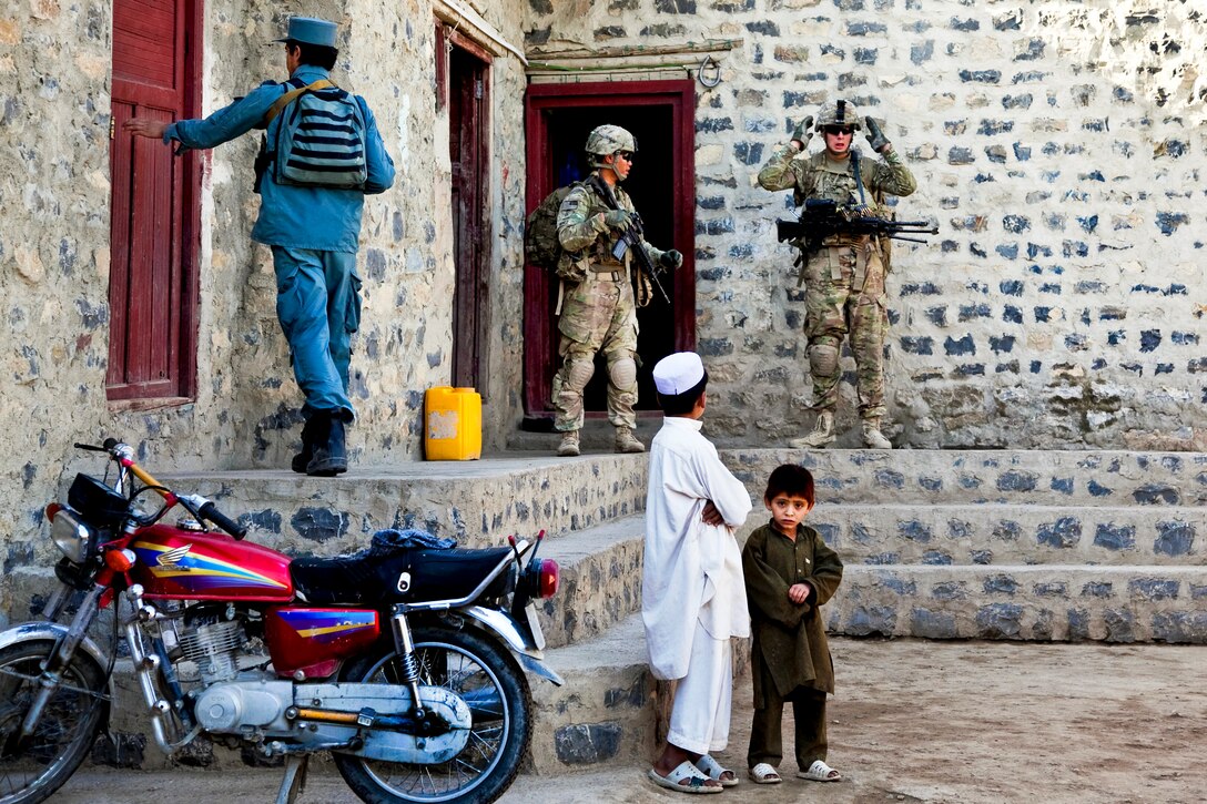 U.S. soldiers and Afghan policemen search for weapons caches in the village of Loy Murghoz in Afghanistan's Khowst province, June 8, 2012. 
