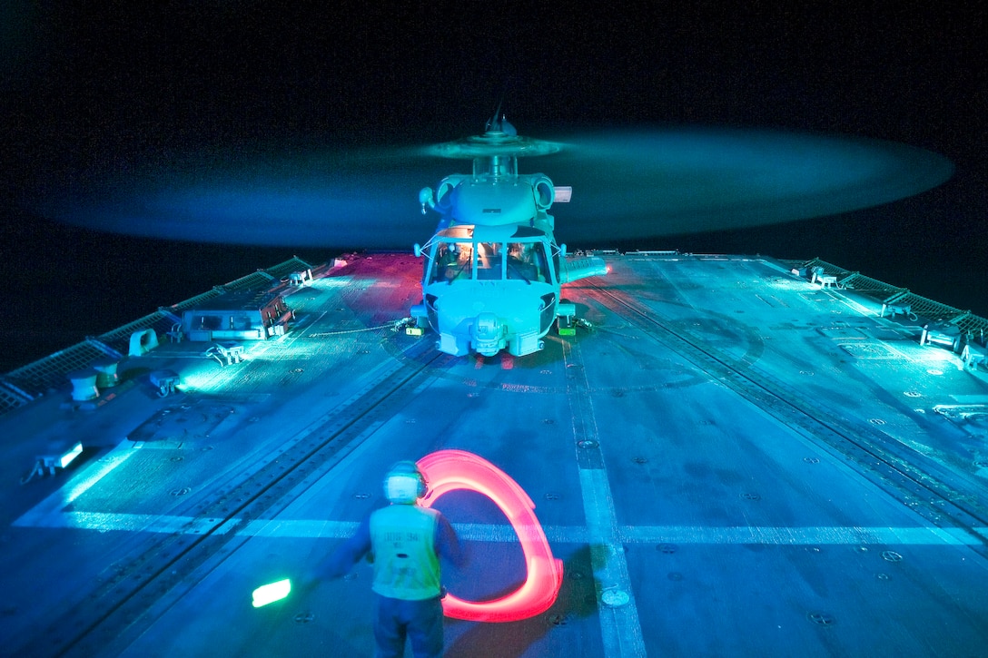 A U.S. Navy sailor directs an SH-60B Seahawk helicopter as it prepares to shut down after landing aboard the guided-missile destroyer USS Nitze in the Gulf of Aden, June 15, 2012. The Nitze is deployed as part of Enterprise Carrier Strike Group to the U.S. 5th Fleet area of responsibility conducting maritime security operations, theater security cooperation efforts and support missions as part of Operation Enduring Freedom.  
