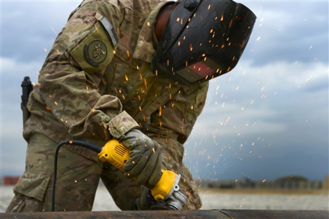 U.S. Air Force Airman 1st Class Demetrius Brown grinds down a drainage pipe on Bagram Airfield, Afghanistan, May 17, 2014. Brown is assigned to the 577th Expeditionary Prime Base Engineer Emergency Force Squadron. 
