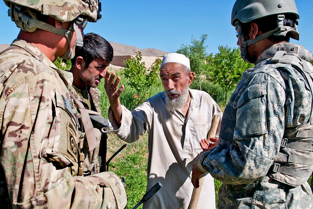 An Afghan villager asks U.S. Army 1st Lt. Kirk Shoemaker, left, if his soldiers can skirt around his fields to avoid damaging his crops in Afghanistan's Ghazni province, June 3, 2012. Shoemaker, assigned to the 82nd Airborne Division's 1st Brigade Combat Team, tells the farmer his men generally spread out while moving through fields.  
