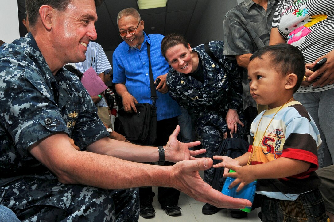 U.S. Navy Capt. James Morgan, mission commander of Pacific Partnership 2012, reaches out to a prospective pediatric surgery patient during a screening program at Siloam Hospital in Manado, Indonesia, June 6, 2012. The goal of the annual U.S. Pacific Fleet humanitarian and civic assistance mission is to build stronger relationships and develop disaster response capabilities throughout the Asia-Pacific region.  
