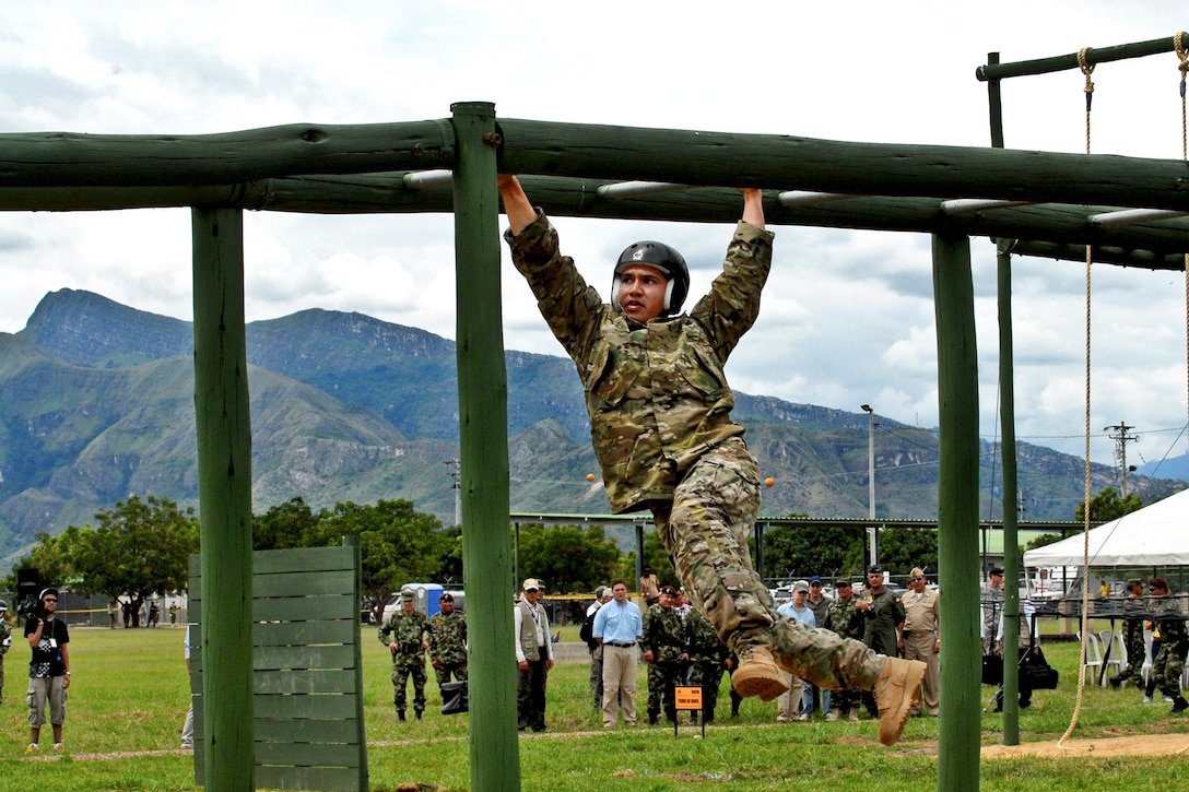 A U.S. Special operations forces member works his way across the monkey bars during the obstacle course portion of Fuerzas Comando 2012 at the Colombian National Training Center on Fort Tolemaida, Colombia, June 10, 2012. The competition is sponsored by U.S. Southern Command.  

