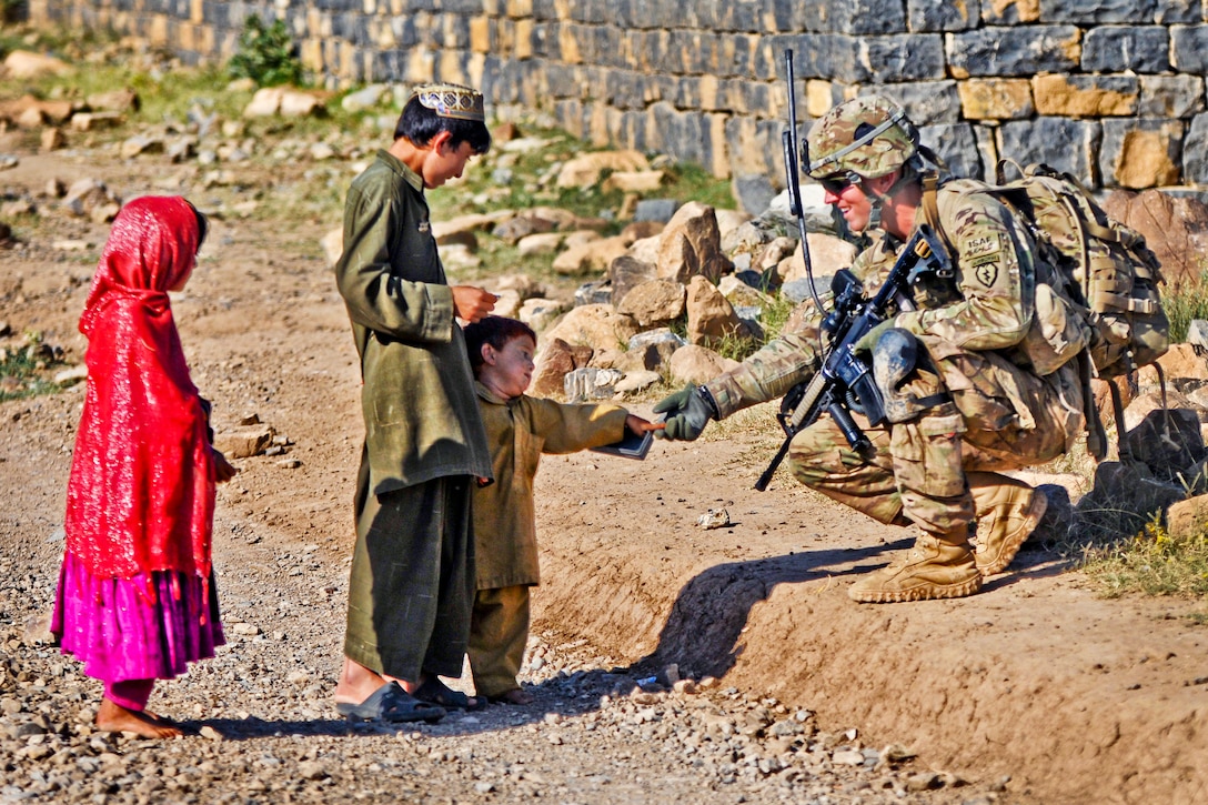 U.S. Army Cpl. Brian Lewis greats an Afghan boy while conducting a dismounted patrol in Shaway Valley in Afghanistan's Khowst province, June 2, 2012. Lewis, a team leader, is assigned to Company B, 1st Battalion, 501st Infantry Regiment.  
