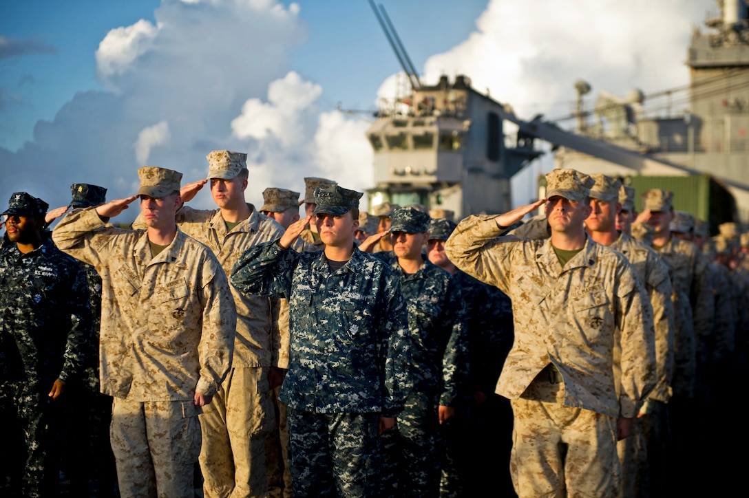 U.S. sailors serving aboard USS Pearl Harbor, joined by embarked Marines and sailors assigned to the 11th Marine Expeditionary Unit, attend a ceremony to commemorate the Battle of Midway while under way in the Pacific Ocean, June 4, 2012. The unit is on a seven-month deployment to the Western Pacific, Horn of Africa and Middle East regions.  
