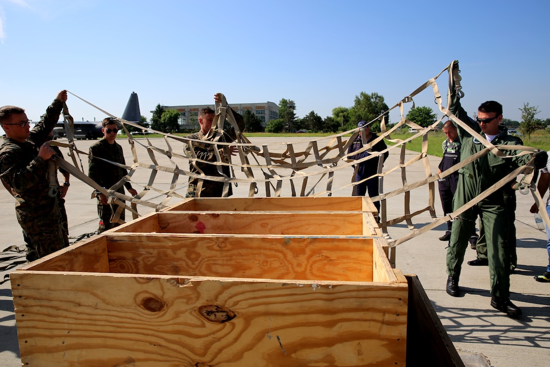 Marines with Black Sea Rotational Force 14, from 3rd Battalion, 8th Marine Regiment, use netting to tie down cargo onto a pallet with Romanian service members during a pallet building military-to-military engagement on Mihail Kogalniceanu Air Base, May 28, 2014. The Marines and Romanians worked together, exchanging pallet building techniques, different equipment and aircraft loading procedures during the military to military engagement in order to learn effective tactics from each other and increase interoperability between the two nations’ embarking units. 