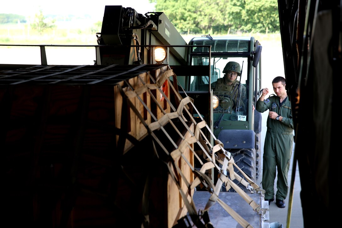 U.S. Marine Cpl. Brandon Glavin, a parachute rigger with Black Sea Rotational Force 14, from 3rd Battalion, 8th Marine Regiment, uses a forklift to load an aircraft with the guidance of a Romanian service member during a pallet building military-to-military engagement with U.S. Marines and Romanians aboard Mihail Kogalniceanu Air Base, May 28, 2014. The Marines and Romanians worked together, exchanging pallet building techniques, different equipment and aircraft loading procedures during the military to military engagement in order to learn effective tactics from each other and increase interoperability between the two nations’ embarking units.  