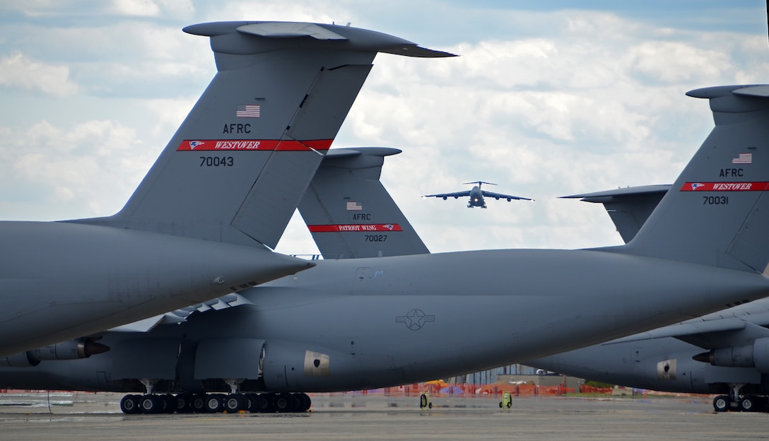 C-5 Galaxy tails on the flightline frame a C-5 on final approach May 19, 2014, to Westover Air Reserve Base, Mass. The C-5 has the ability to carry 36 standard pallets and 81 troops simultaneously. (US Air Force photo/Master Sgt. Andrew Biscoe)