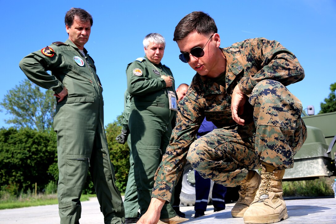 U.S. Marine Cpl. Ryan Emma, a landing-support specialist with Black Sea Rotational Force 14, from 3rd Battalion, 8th Marine Regiment, explains Marine Corps loading techniques to Romanian members during a pallet building military-to-military engagement on Mihail Kogalniceanu Air Base, May 28, 2014. The Marines and Romanians worked together, exchanging pallet building techniques, different equipment and aircraft loading procedures during the military to military engagement in order to learn effective tactics from each other and increase interoperability between the two nations’ embarking units. 