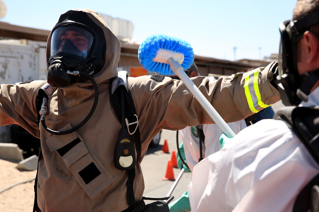 A firefighter with the Combat Center Fire Department's hazardous material team is scrubbed down after leaving a notionally contaminated area of the post office, during Postal Exercise 2014 May 21, 2014. The scenario was conducted by Exercise Team West and Combat Center units.