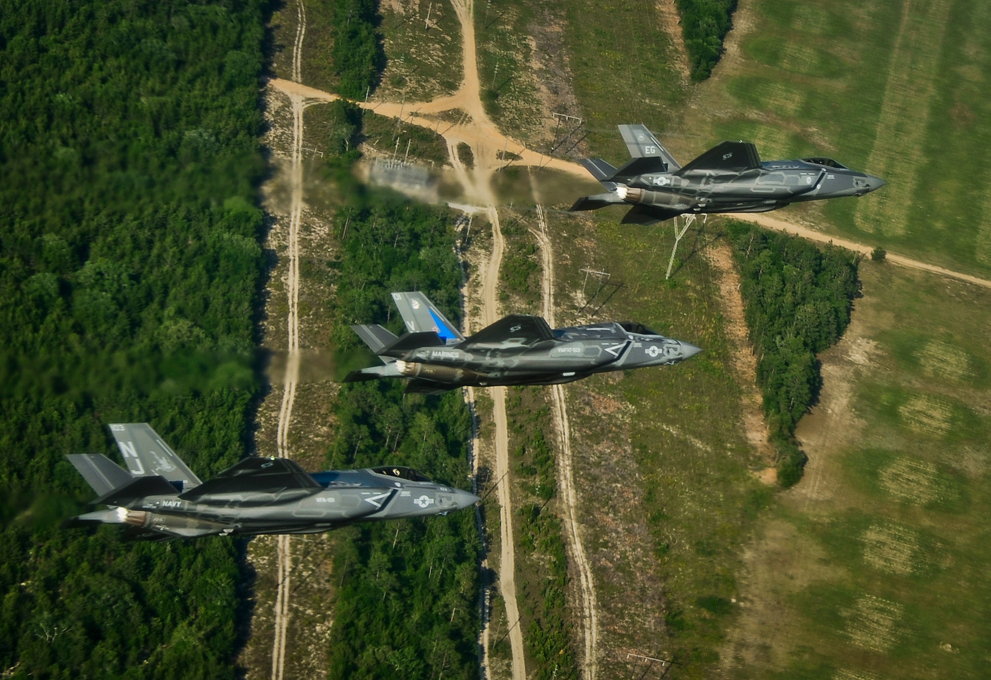 A Navy F-35C, a Marine Corps F-35B, and an Air Force F-35A Lightning II participate in a training sortie together May 21, 2014, near Eglin Air Force Base, Fla. The F-35 Integrated Training Center at Eglin AFB surpassed 5,000 combined training sorties May 28, 2014, contributing more than a third of all sorties in the Department of Defense’s F-35 program. All three variants of the fifth generation multirole stealth fighter are hosted by the 33rd Fighter Wing here. The F-35 is designed with the stealth, electronic warfare, and multi-spectral fused sensor capabilities, which will increase lethality and survivability in a contested environment. (U.S. Air Force photo/Staff Sgt. Joely M. Santiago)