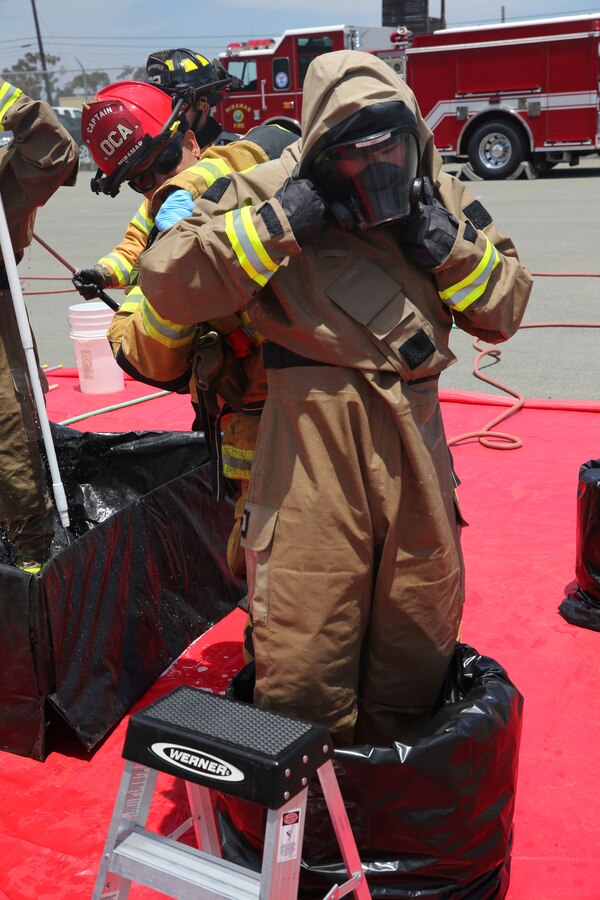 Cpl. Ernest Andrews, an Aircraft Rescue and Firefighting specialist with Headquarters and Headquarters Squadron, takes off his HAZMAT suit after going through the decontamination process aboard Marine Corps Air Station Miramar, Calif., May 29. Andrews collected samples at the contamination site during the exercise to be sent to the San Diego Vector Disease and Diagnostic Lab to determine if there is a contamination.  