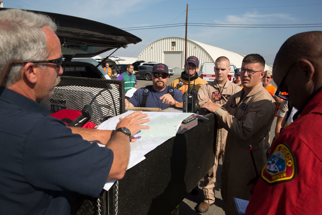 Marines with Aircraft Rescue and Firefighting coordinate with San Diego Fire-Rescue Department and the Marine Corps Air Station Miramar Fire Department to set up an instant command center before collecting possible contaminated samples during an exercise aboard MCAS Miramar, Calif., May 29. The training was held to certify the efficiency of all the groups working together.