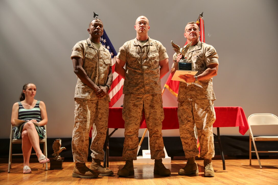 Sgt. Michael McIntire stands with 2nd Marine Aircraft Wing commanding general and command sergeant major, Maj. Gen. Robert Hedelund and Sgt. Maj. Christopher Robinson, before receiving an award, May 20. The award, sponsored by the Navy and Marine Association, is given to leaders considered to be ethical, proud, and professional.