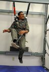 Kirby Balinski, a teenager battling Hodgkin’s Lymphoma, hangs in the virtual reality parachute trainer during a tour of the 15th Operations Support Squadron Aircrew Flight Equipment  section as part of the Pilot For a Day program at Joint Base Pearl Harbor-Hickam, Hawaii, May 29, 2014. (U.S. Air Force photo/Tech. Sgt. Terri Paden)