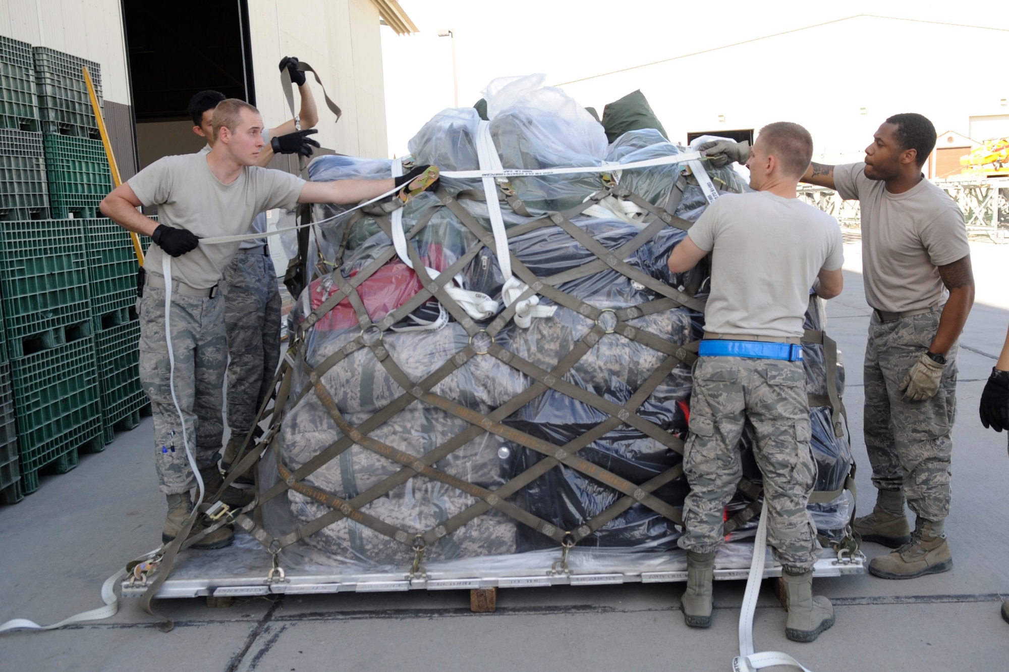 Airmen from the 366th Logistics Readiness Squadron build pallets for transportation, May 29, 2014, at Mountain Home Air Force Base, Idaho. Preparing luggage for transportation is just one way LRS has supported the deployment. (U.S. Air Force photo by Senior Airman Caitlin Guinazu/Released) 