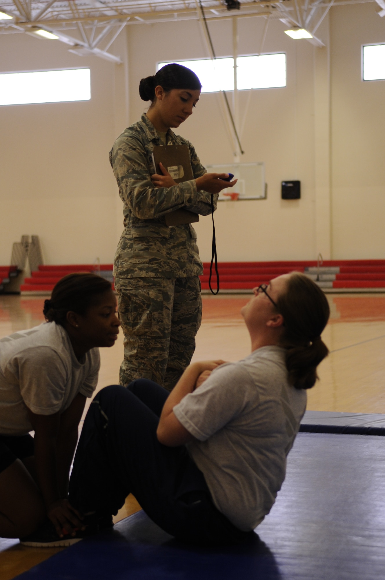 2nd Lt. Danielle Caudill, 30th Force Support Squadron fitness assessment cell officer-in-charge, conducts the sit-up portion of an Official Fitness Assessment, May 29, 2014, Vandenberg Air Force Base, Calif. With military members continuing to focus on global operations, maintaining fitness levels in the Air Force is a constant priority. (U.S. Air Force photo by Senior Airman Shane M. Phipps/Released)

