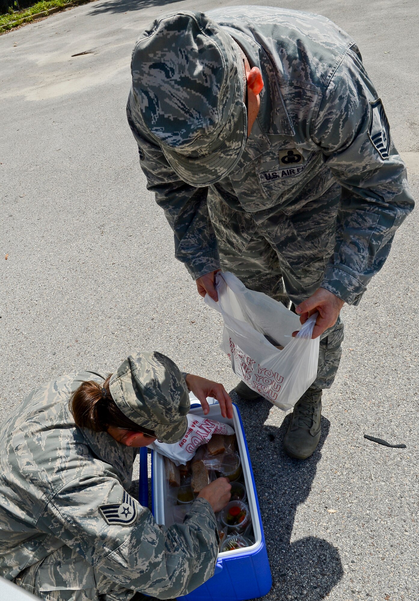 Staff Sgt. Katie Patterson and Master Sgt. Wayne Parsons, 6th Air Mobility Wing Meals on Wheels volunteers, bag a meal while delivering meals to the elderly May 29, 2014 in Tampa, Fla. MOW of Tampa serve approximately 750 meals per day. (U.S. Air Force photo by Senior Airman Jenay Randolph/Released)