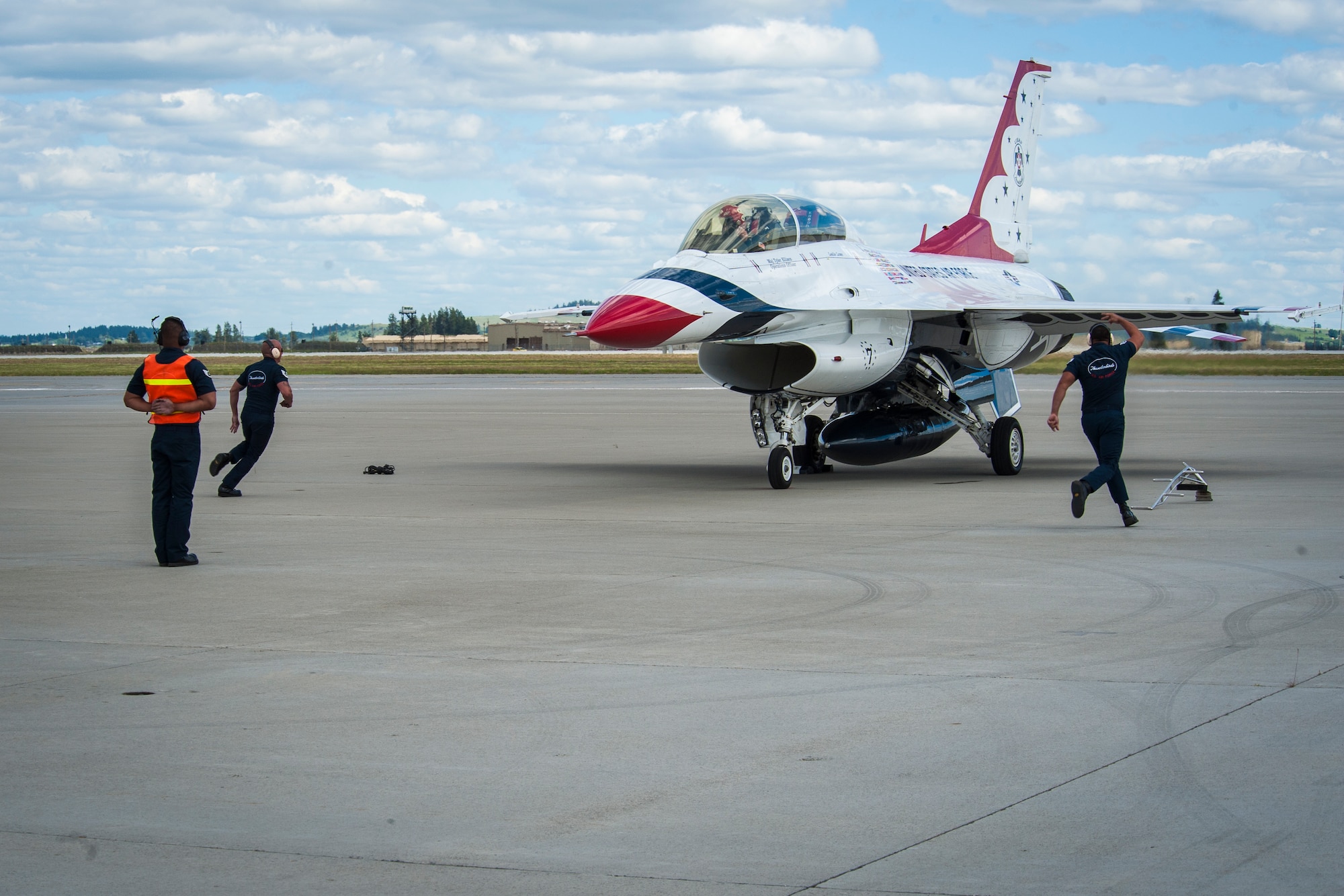 Crew chiefs prepare a U.S. Air Force Thunderbird with orientation flight rider, Leslie Lowe, for takeoff as part of SkyFest 2014 at Fairchild Air Force Base, Wash., May 29, 2014. The Thunderbirds is an Air Combat Command unit composed of eight pilots, including six demonstration pilots, four support officers, three civilians and more than 130 enlisted personnel performing in 25 career fields. SkyFest is Fairchild’s air show and open house, giving the local and regional community the opportunity to view Airmen and our resources. Lowe is a KHQ 6 reporter. (U.S. Air Force photo by Staff Sgt. Benjamin W. Stratton/Released)