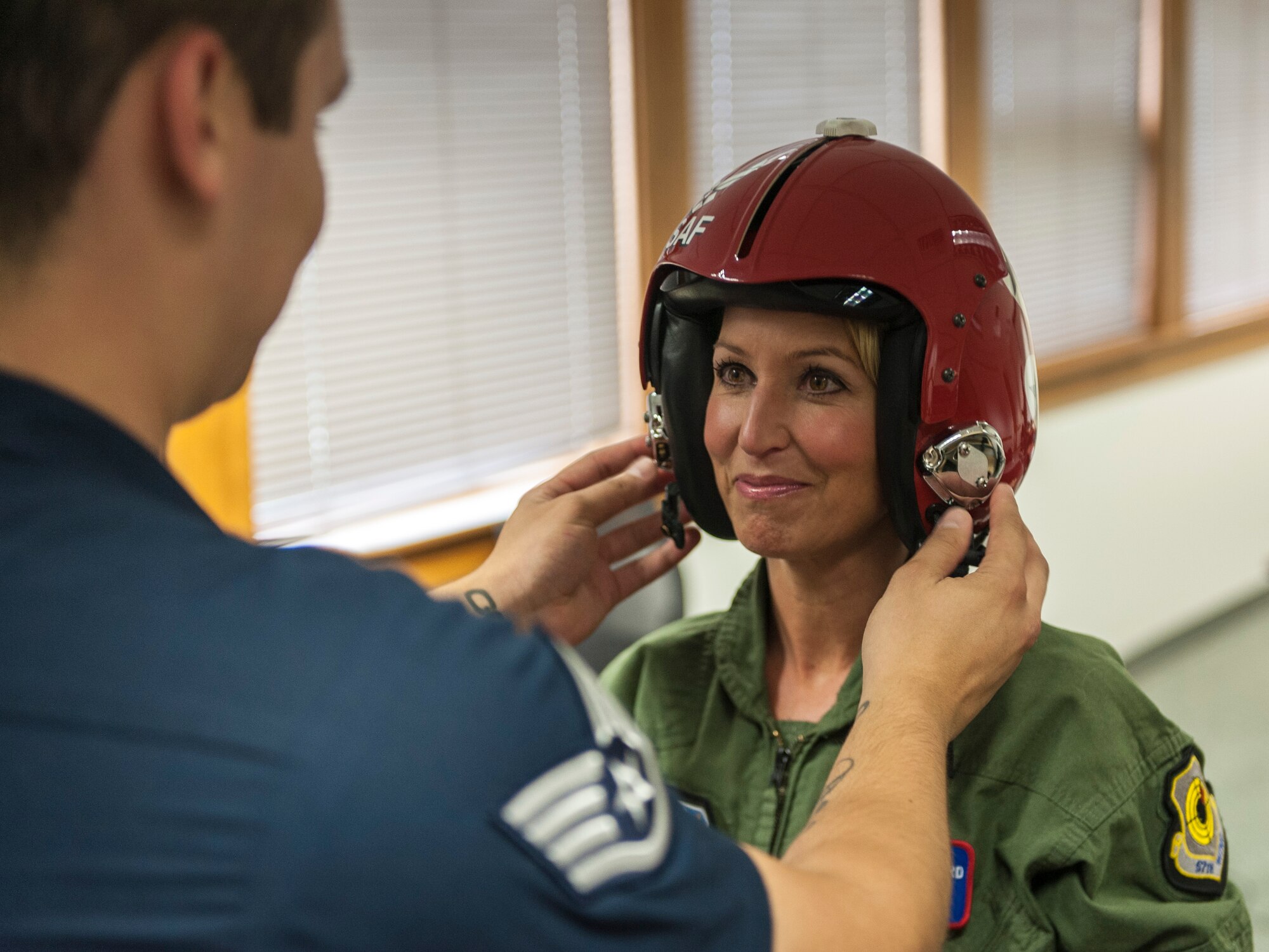 Staff Sgt. Jose Ibarra sizes Leslie Lowe for her helmet and mask in preparation for a U.S. Air Force Thunderbirds orientation flight as part of SkyFest 2014 at Fairchild Air Force Base, Wash., May 29, 2014. The Thunderbirds is an Air Combat Command unit composed of eight pilots, including six demonstration pilots, four support officers, three civilians and more than 130 enlisted personnel performing in 25 career fields. SkyFest is Fairchild’s air show and open house, giving the local and regional community the opportunity to view Airmen and our resources. Ibarra is a Thunderbirds aircrew flight equipment specialist here from Nellis AFB, Nev., and Lowe is a KHQ 6 reporter. (U.S. Air Force photo by Staff Sgt. Benjamin W. Stratton/Released)