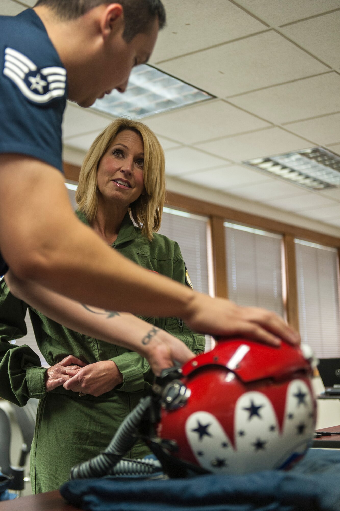 Staff Sgt. Jose Ibarra explains to Leslie Lowe how to use her helmet and mask in preparation for a U.S. Air Force Thunderbirds orientation flight as part of SkyFest 2014 at Fairchild Air Force Base, Wash., May 29, 2014. The Thunderbirds is an Air Combat Command unit composed of eight pilots, including six demonstration pilots, four support officers, three civilians and more than 130 enlisted personnel performing in 25 career fields. SkyFest is Fairchild’s air show and open house, giving the local and regional community the opportunity to view Airmen and our resources. Ibarra is a Thunderbirds aircrew flight equipment specialist here from Nellis AFB, Nev., and Lowe is a KHQ 6 reporter. (U.S. Air Force photo by Staff Sgt. Benjamin W. Stratton/Released)