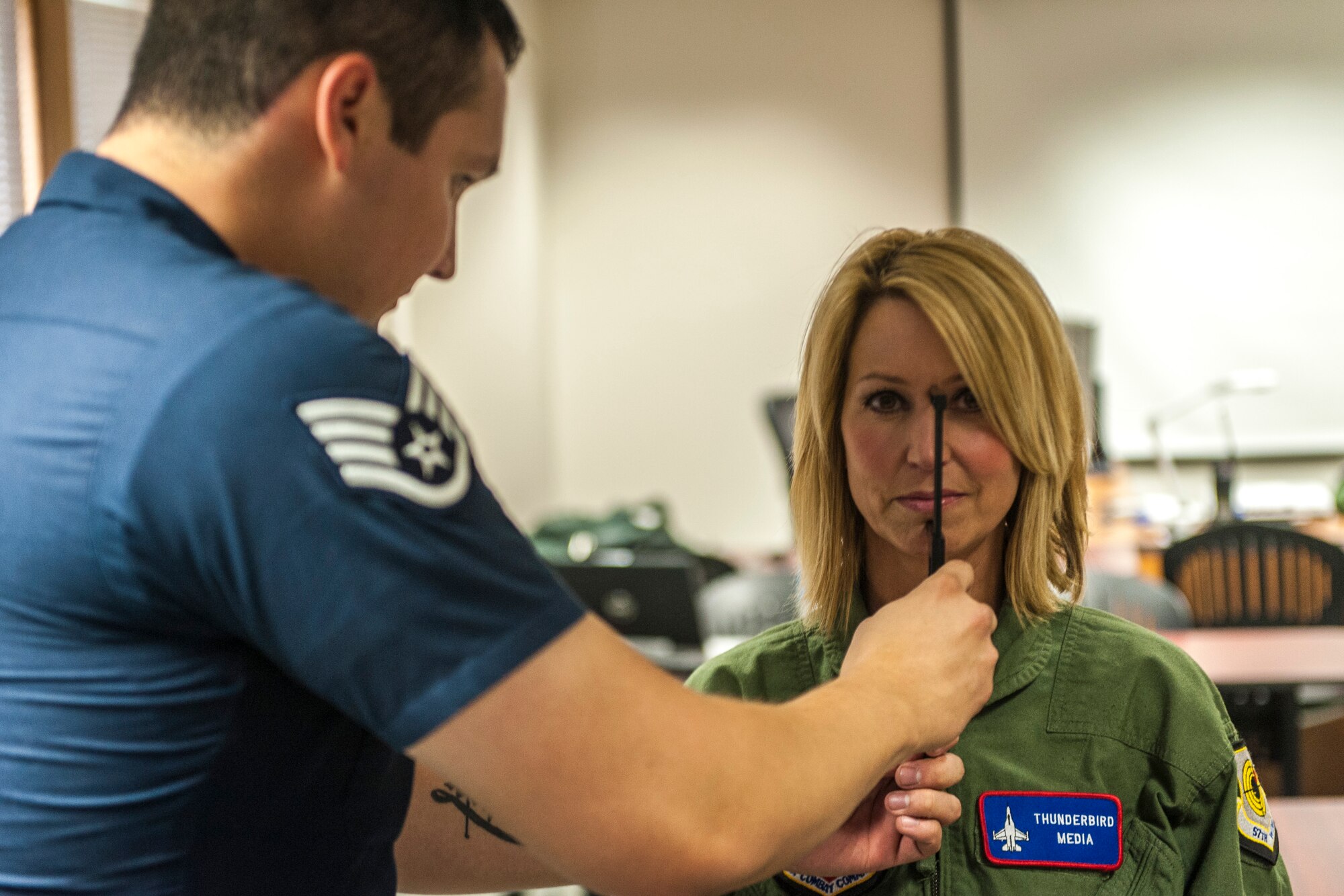 Staff Sgt. Jose Ibarra sizes Leslie Lowe for her helmet and mask in preparation for a U.S. Air Force Thunderbirds orientation flight as part of SkyFest 2014 at Fairchild Air Force Base, Wash., May 29, 2014. The Thunderbirds is an Air Combat Command unit composed of eight pilots, including six demonstration pilots, four support officers, three civilians and more than 130 enlisted personnel performing in 25 career fields. SkyFest is Fairchild’s air show and open house, giving the local and regional community the opportunity to view Airmen and our resources. Ibarra is a Thunderbirds aircrew flight equipment specialist here from Nellis AFB, Nev., and Lowe is a KHQ 6 reporter. (U.S. Air Force photo by Staff Sgt. Benjamin W. Stratton/Released)