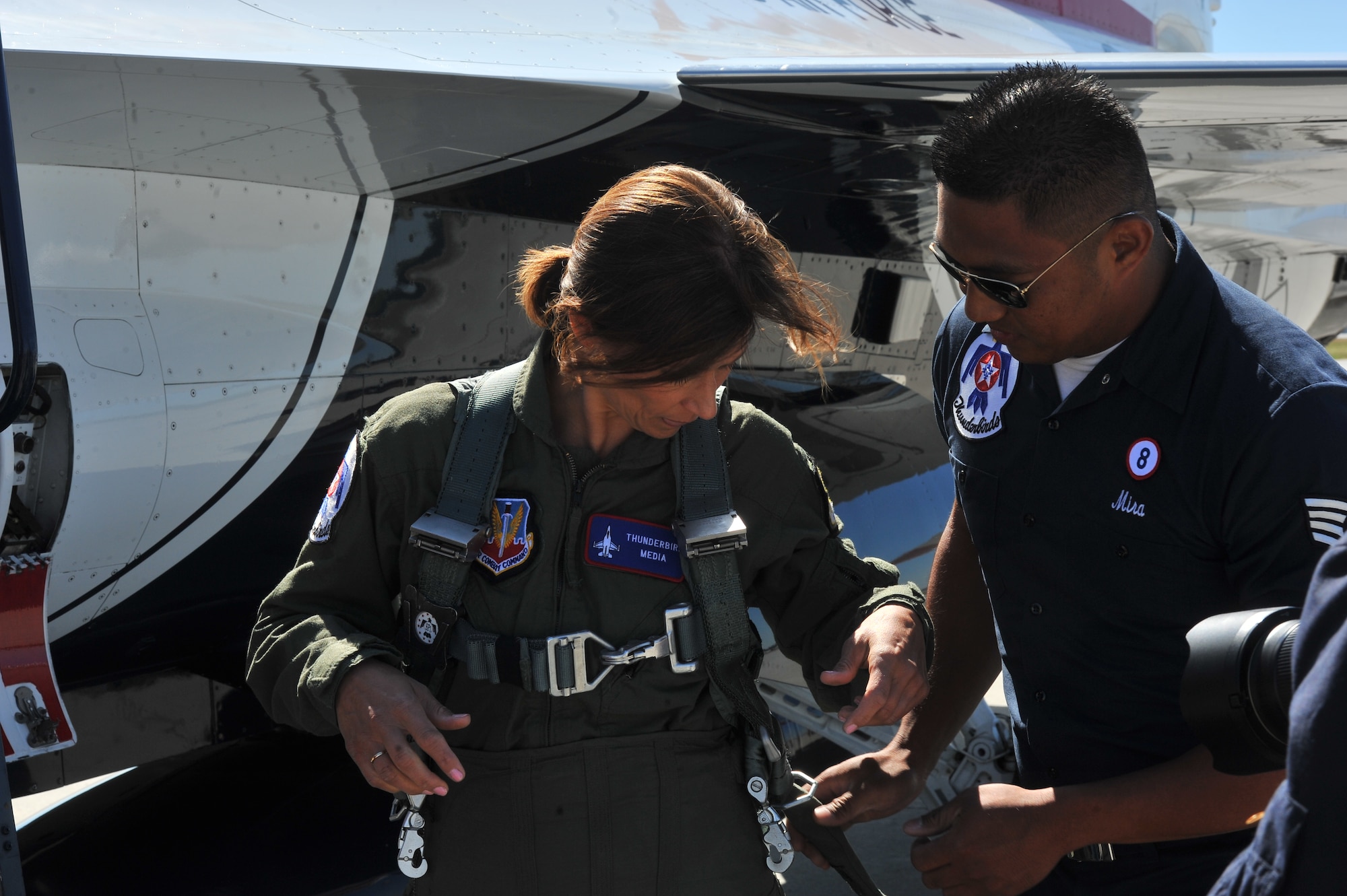 Staff. Sgt. Mark Mira, U.S. Air Force Thunderbirds crew chief, assists Robyn Nance, KXLY news anchor, for her flight in the F-16 Fighting Falcon before SkyFest 2014 at Fairchild Air Force Base, Wash., May 30, 2014.  The Thunderbirds is an Air Combat Command unit composed of eight pilots, including six demonstration pilots, four support officers, three civilians and more than 130 enlisted personnel performing in 25 career fields. (U.S. Air Force photo by Staff Sgt. Veronica Montes)
