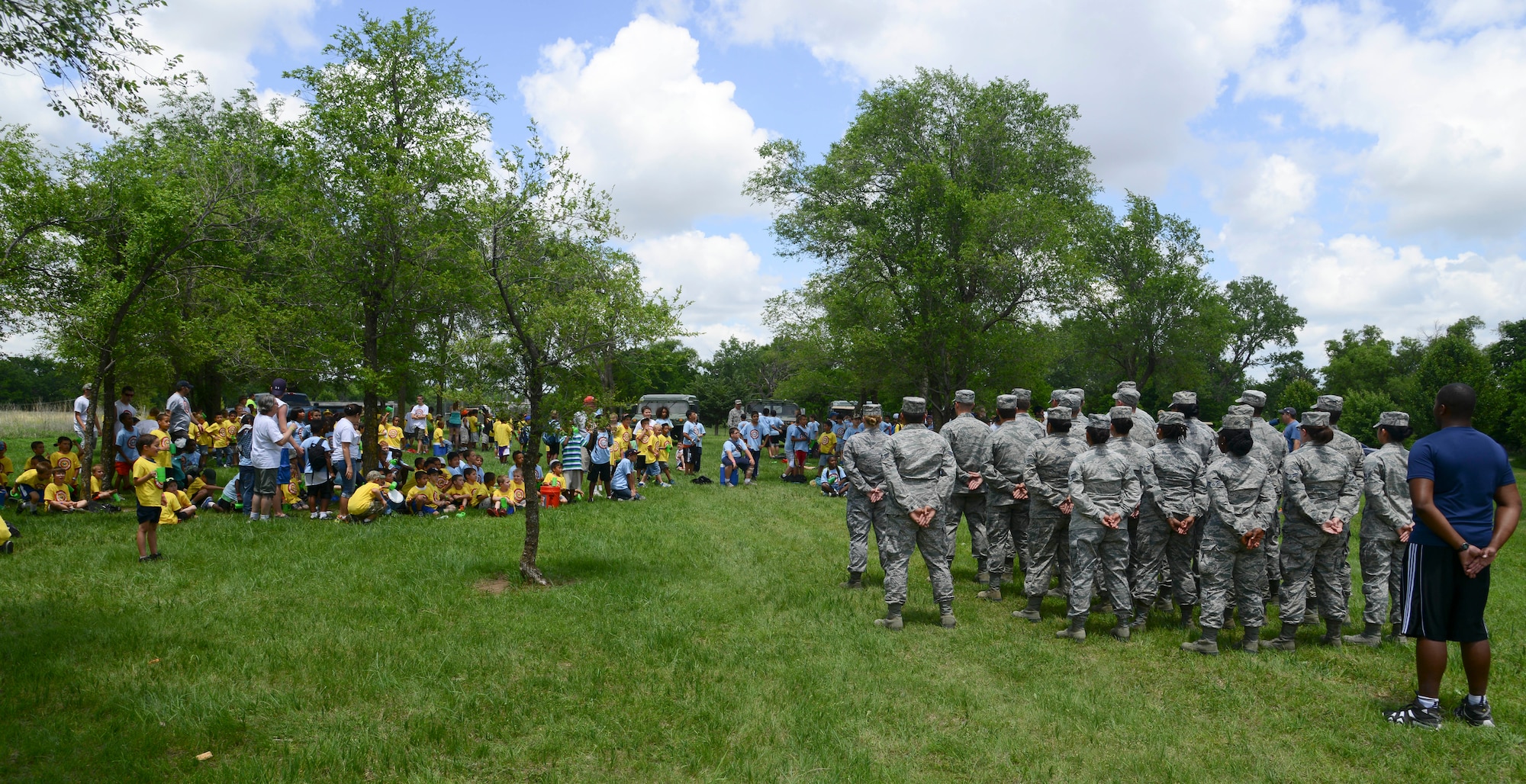 Airmen from McConnell Air Force Base, Kan., stand at parade rest in front of children May 30, 2014, at the Jim James Memorial 101 Club, Wichita, Kan. Airmen spent three days leading children through activities at the 2014 Boy Scouts of America Awareness Camp. (U.S. Air Force photo/Airman 1st Class John Linzmeier)