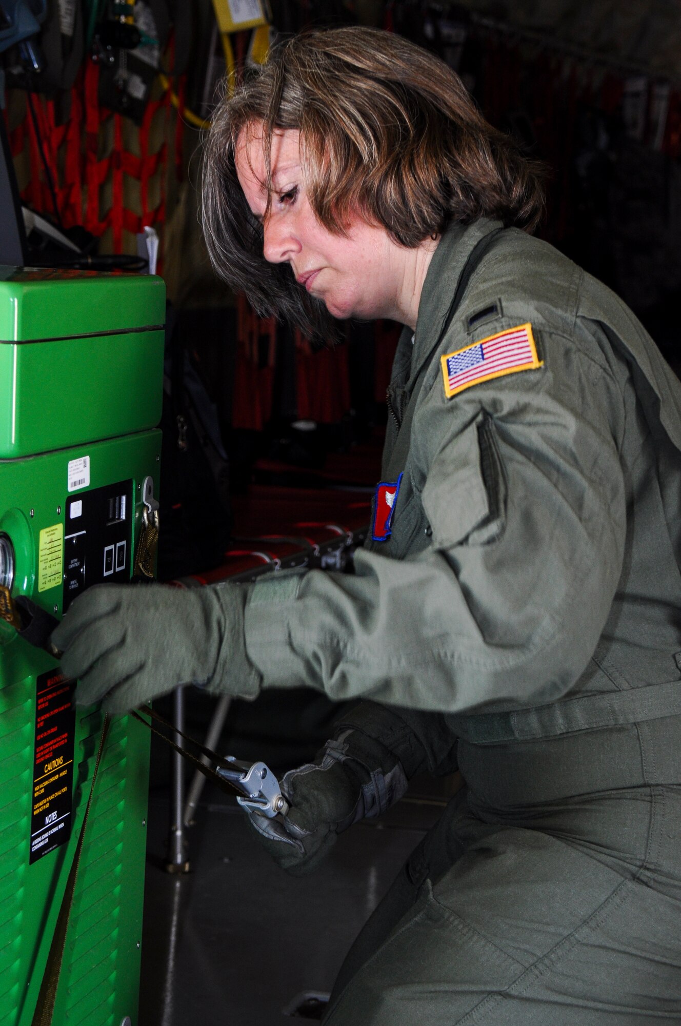 First Lieutenant Denee Norman, 137th Oklahoma Air National Guard Aeromedical Evacuation Squadron flight nurse, secures a strap on a liquid oxygen unit to be used during a medical and refueling training mission on May 29th, 2014 at Tinker Air Force Base. (U.S. Air Force Photo/Senior Airman Mark Hybers)
