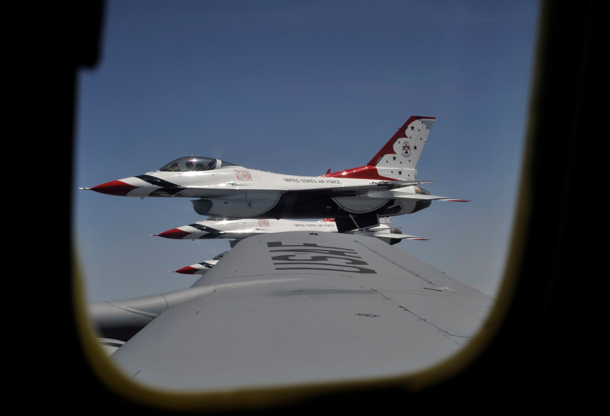 Members of the U.S. Air Force Thunderbird team fly along next to a KC-135 Stratotanker while being escorted to Fairchild Air Force Base, Wash., May 29, 2014. Members of Fairchild's local media agencies were able to fly on this escort and air refueling mission as an orientation flight to prepare communities for the upcoming air show. (U.S. Air Force photo by Senior Airman Mary O'Dell/Released)