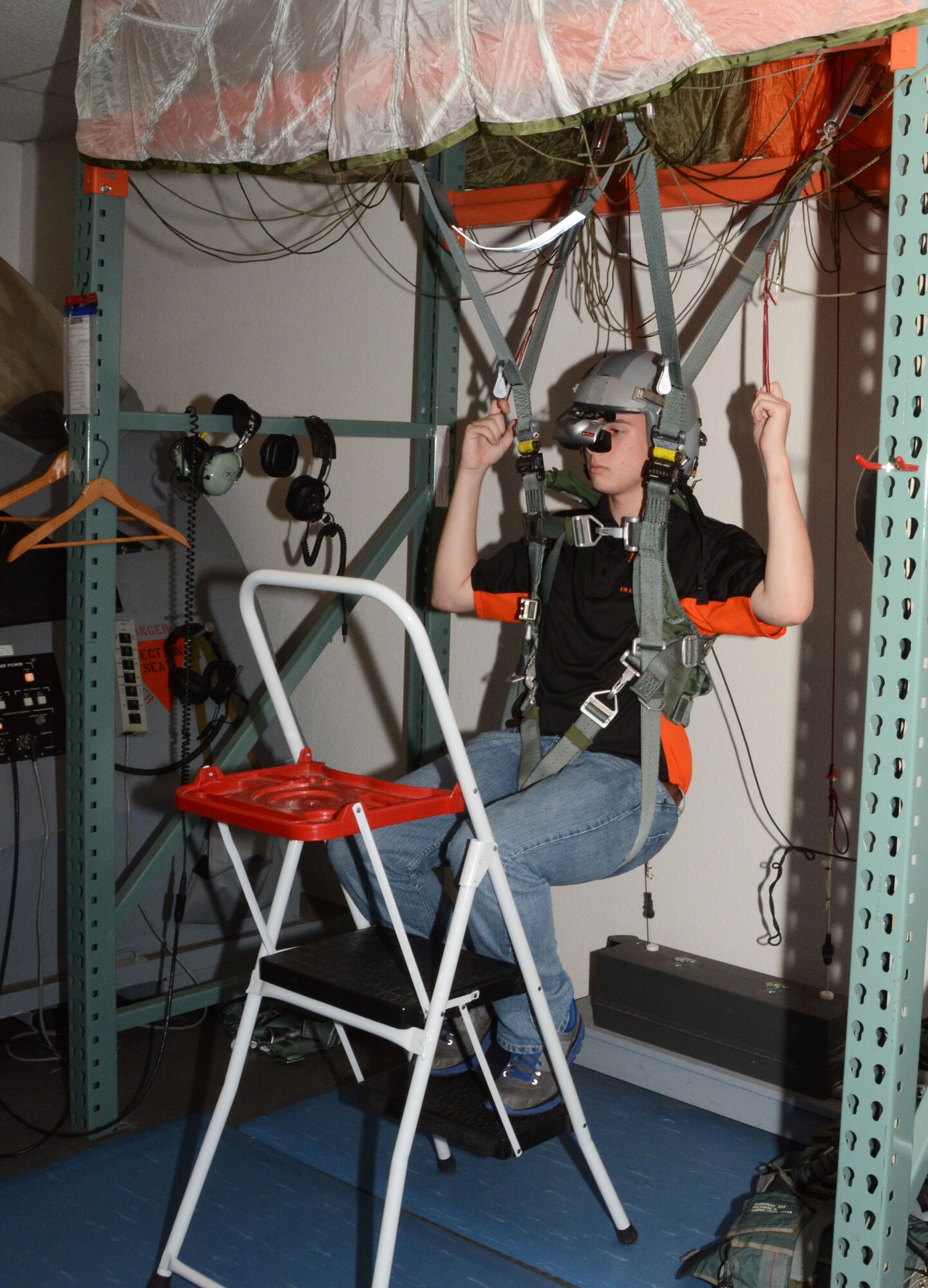 A member of the Junior Reserve Officer Training Corps, Madison Central High School, Madison, Mississippi, sits in a parachute simulator, May 29, 2014, Naval Air Station Fort Worth Joint Reserve Base, Texas. The students are visiting the 301st Fighter Wing to learn about the different career fields the Air Force has to offer. (U.S. Air Force photo by Staff Sgt. Samantha A. Mathison)