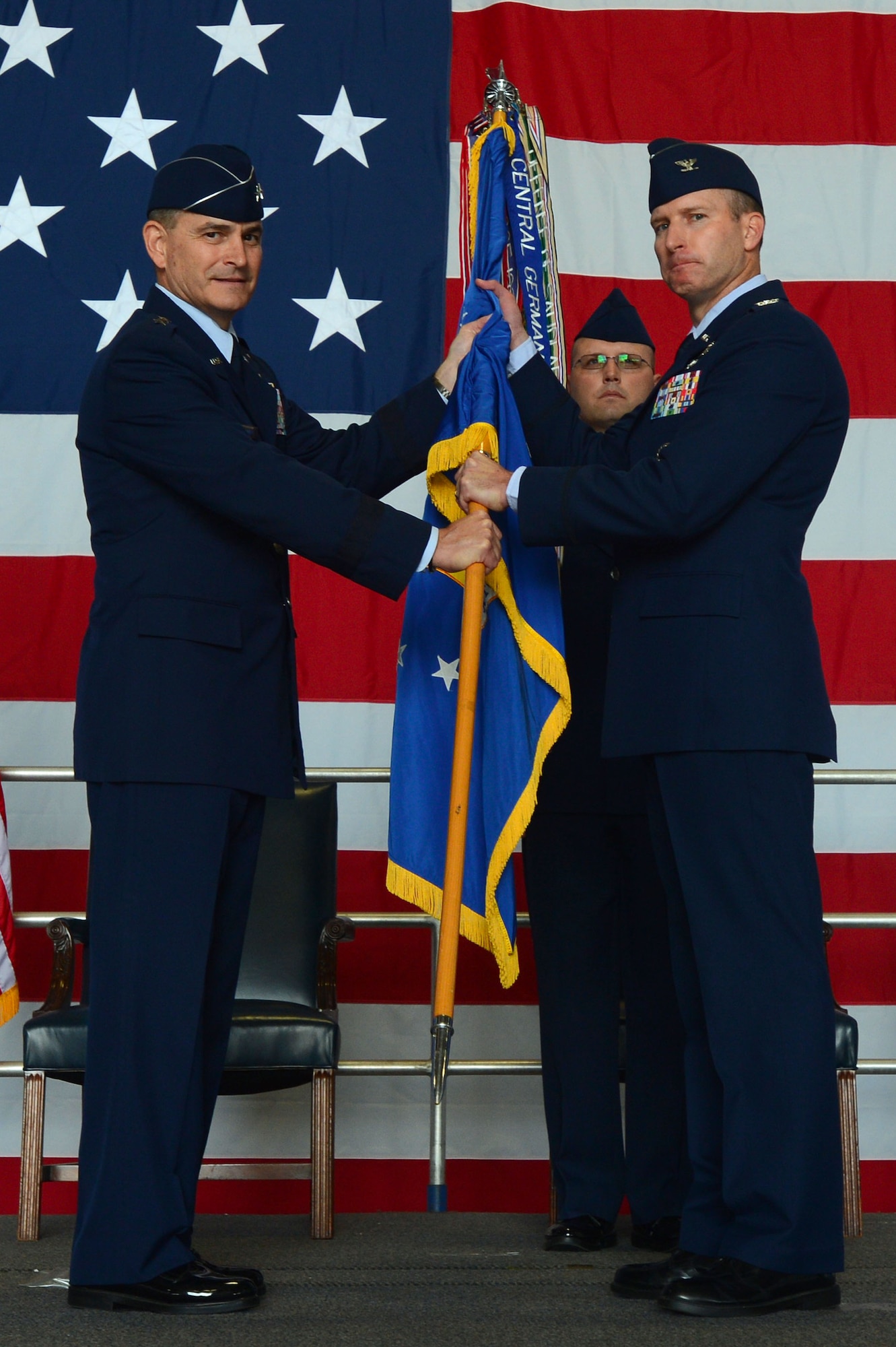 U.S. Air Force Col. Stephen Jost, 20th FW commander, receives the 20th Fighter Wing guidon from Maj. Gen. Jake Polumbo, Ninth Air Force commander, as he assumes command of the wing during a change of command ceremony at Shaw Air Force Base, S.C., May 30, 2014. Outgoing and incoming commanders exchange unit guidons to symbolize relinquishment and assumption of command. (U.S. Air Force photo by Airman 1st class Jensen Stidham/Released)