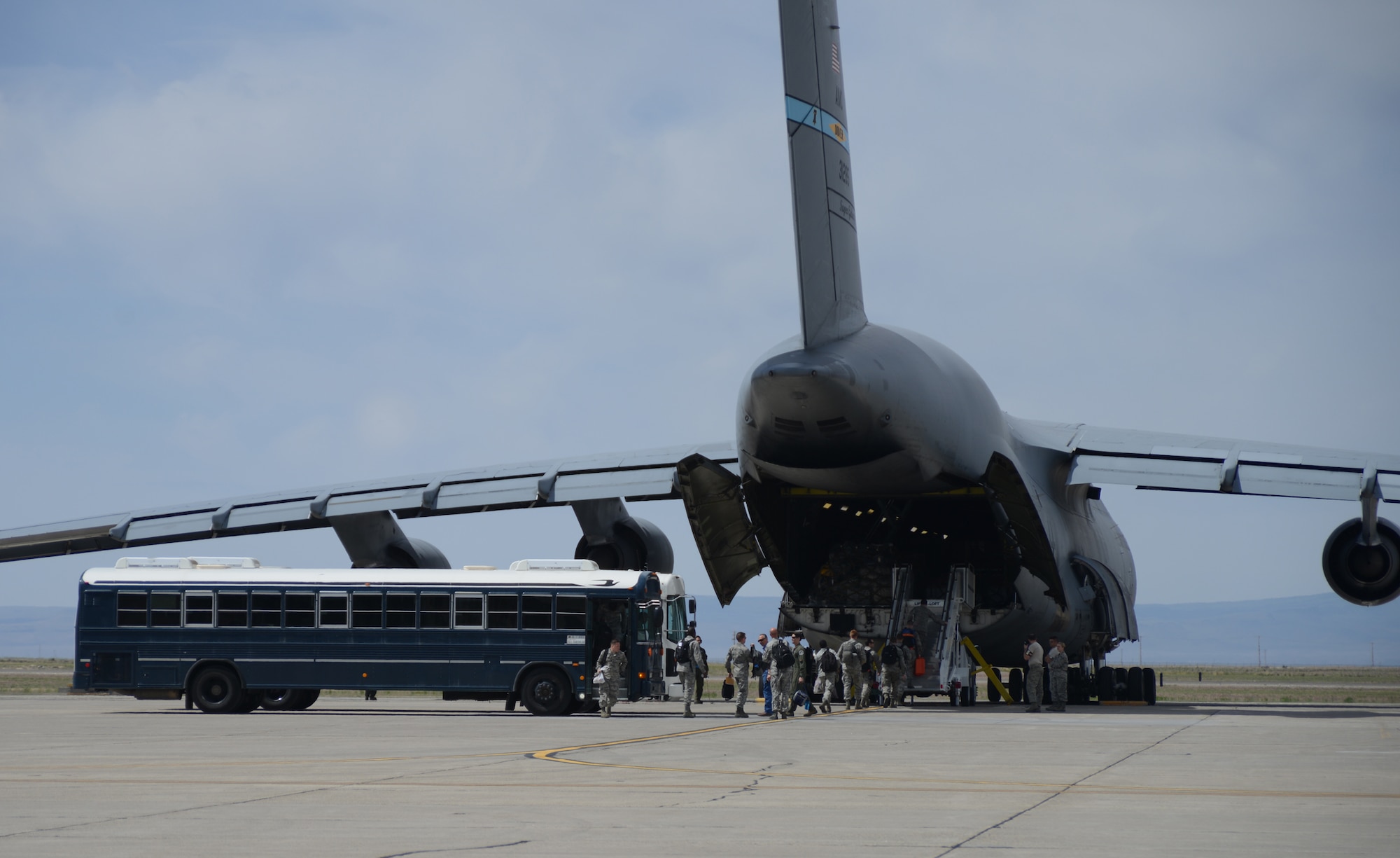 Gunfighters assigned to the 366th Fighter Wing exit a bus and board C-5M Super Galaxy May 30, 2014, at Mountain Home Air Force Base, Idaho. Movement of U.S. Air Force fighters and personnel  into the Pacific has been a routine and integral part of U.S. Pacific Command's combat capable air forces and regional force posture since March 2004, in order to maintain a prudent deterrent against threats to regional security. (U.S. Air Force photo by Senior Airman Benjamin Sutton/Released)