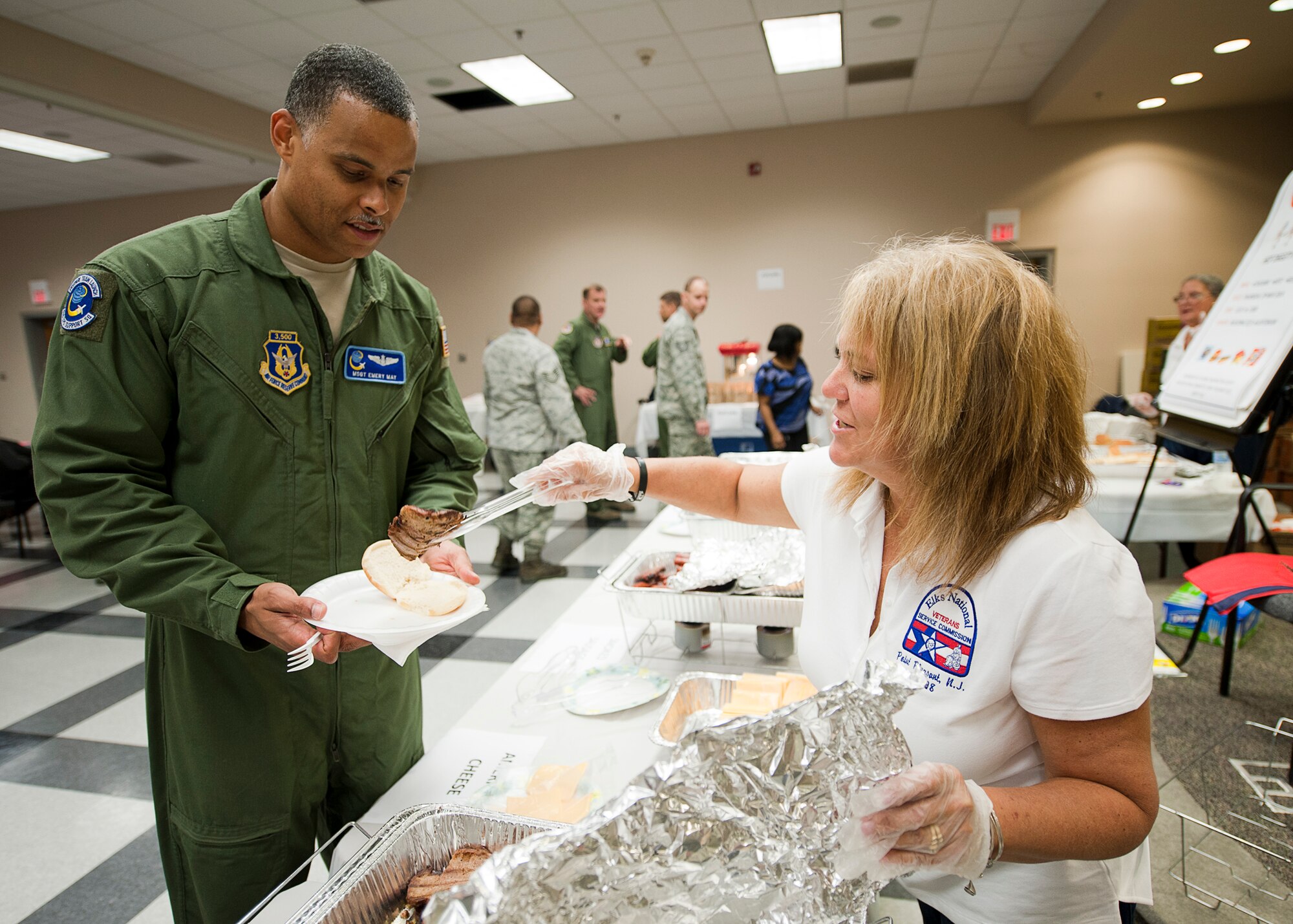 Donna Rotunno, Point Pleasant Elks Lodge, serves Master Sgt. Emory May, 514th Operations Support Squadron, during the 514th Air Mobility Wing's 2nd Annual Hot Diggity Dog luncheon May 29, here (U.S. Air Force photo/Christian DeLuca). 