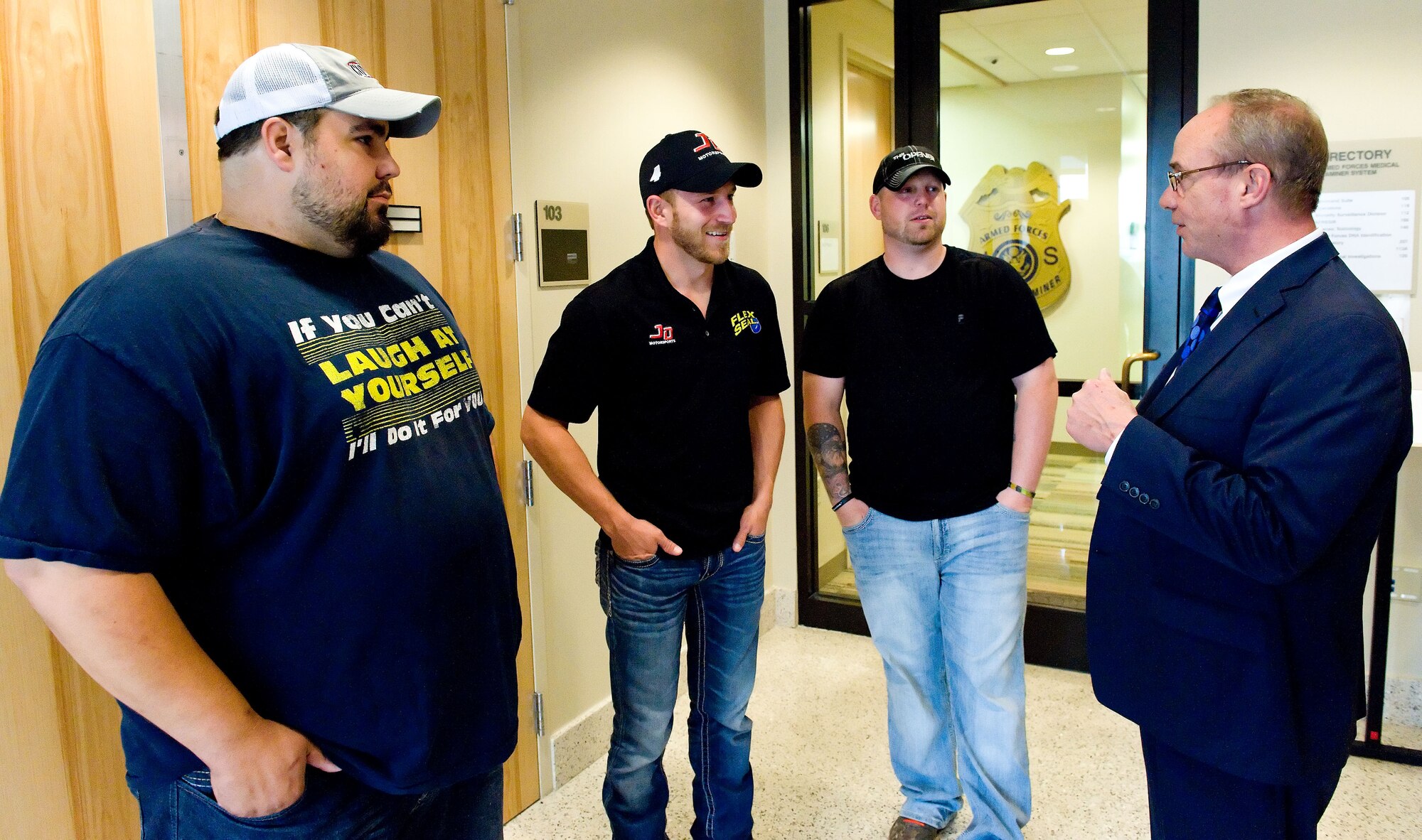 Jeffrey Earnhardt, second from the left, NASCAR Nationwide Series driver of the No. 4 JD Motorsports Chevrolet, talks with Paul Stone, right, Armed Forces Medical Examiner System public affairs officer, May 28, 2014, at Dover Air Force Base, Del. Earnhardt received briefings and a tour of the AFMES facility. (U.S. Air Force photo/Roland Balik)