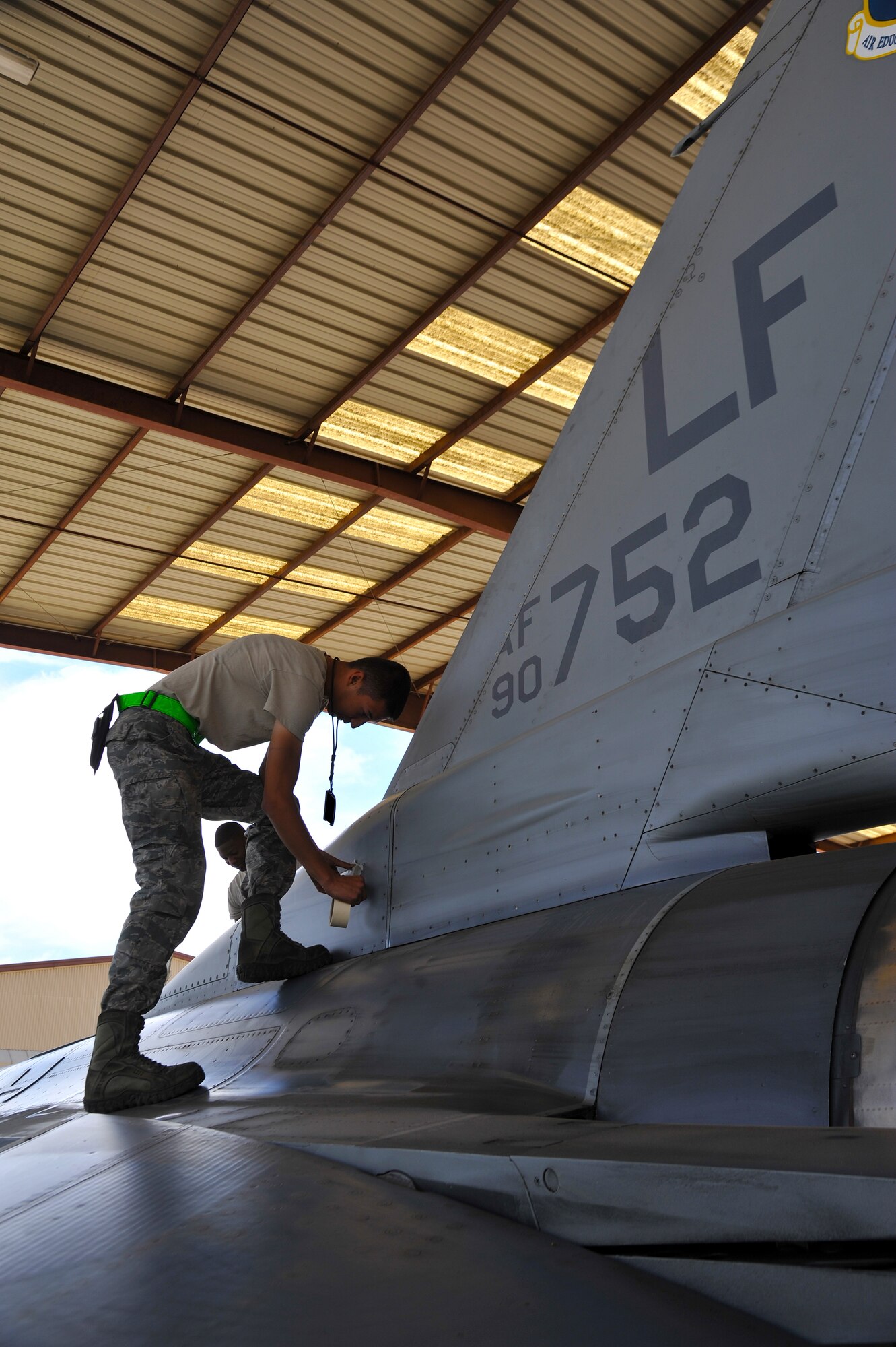Airman 1st Class Anthony Masic, 310th Aircraft Maintenance Unit crew chief, seals areas April 15 where water can seep into the vital systems of an F-16 Fighting Falcon while it is in the wash rack. The 310th AMU washes two of their jets every week. (U.S. Air Force photo/Senior Airman Jason Colbert)