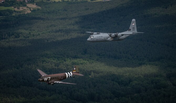 A Douglas C-47 Skytrain, known as Whiskey 7, flies alongside a C-130J Super Hercules from the 37th Airlift Squadron over Germany, May 30, 2014. The C-47 came to Ramstein for a week to participate in base activities with its legacy unit, the 37th Airlift Squadron, before returning to Normandy to recreate its role and drop paratroopers over the original drop zone in Sainte-Mere Eglise, France. (U.S. Air Force photo/Airman 1st Class Jordan Castelan)