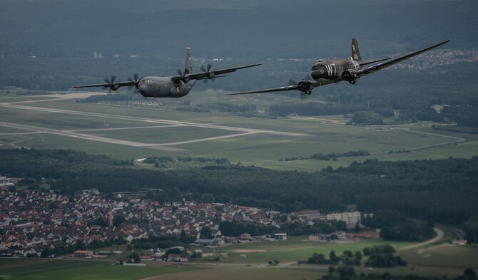 A Douglas C-47 Skytrain, known as Whiskey 7, flies alongside a C-130J Super Hercules from the 37th Airlift Squadron over Germany, May 30, 2014. The C-47 came to Ramstein for a week to participate in base activities with its legacy unit, the 37th Airlift Squadron, before returning to Normandy to recreate its role and drop paratroopers over the original drop zone in Sainte-Mere Eglise, France. (U.S. Air Force photo/Airman 1st Class Jordan Castelan)