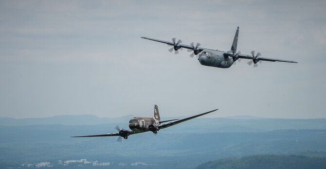 A Douglas C-47 Skytrain, known as Whiskey 7, flies alongside a C-130J Super Hercules from the 37th Airlift Squadron over Germany, May 30, 2014. The C-47 came to Ramstein for a week to participate in base activities with its legacy unit, the 37th Airlift Squadron, before returning to Normandy to recreate its role and drop paratroopers over the original drop zone in Sainte-Mere Eglise, France. (U.S. Air Force photo/Airman 1st Class Jordan Castelan)