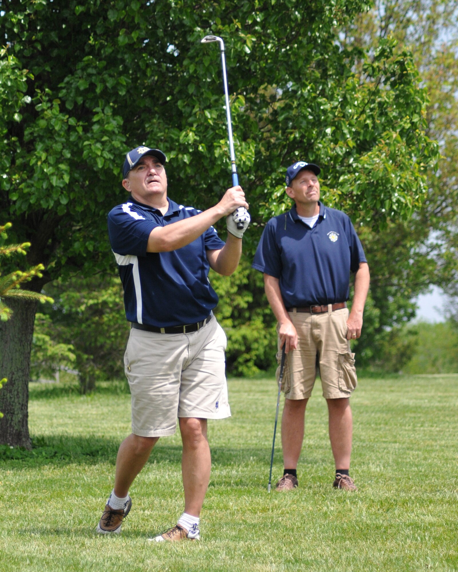Master Sgt. Danny Gilseth (left), 512th Logistics Readiness Squadron, hits a shot from the rough as teammate Richard Stoops Jr., looks on at the annual Central Delaware Chamber of Commerce Bluesuiters Golf Tournament at the Jonathan's Landing Golf Course in Magnolia, Del., May 15, 2014. The event is held annually to promote the relationship between the Dover civilian community and the Dover Air Force Base community. (U.S. Air Force photo/Herbert E. Welday III)