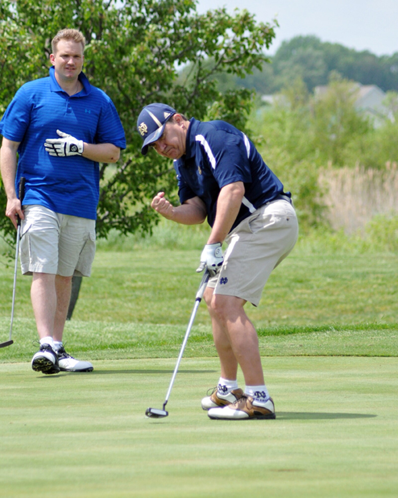 Master Sgt. Danny Gilseth (right), 512th Logistics Readiness Squadron, drained a putt as Master Sgt. Spence Patton, 436th LRS, watched during the annual Central Delaware Chamber of Commerce Bluesuiters Golf Tournament at the Jonathan's Landing Golf Course in Magnolia, Del., May 15, 2014. The event is held annually to promote the relationship between the Dover civilian community and the Dover Air Force Base community. (U.S. Air Force photo/Herbert E. Welday III)